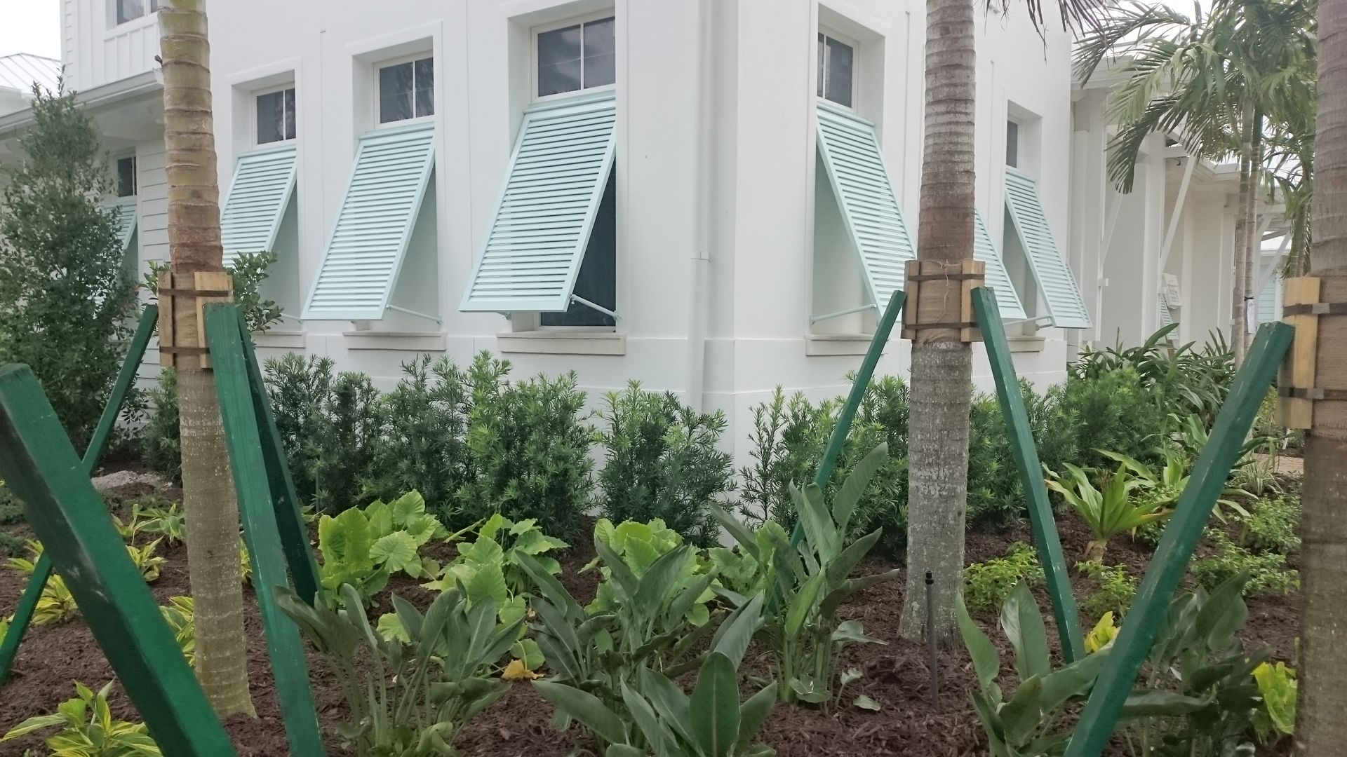 A white building with blue awnings on the windows