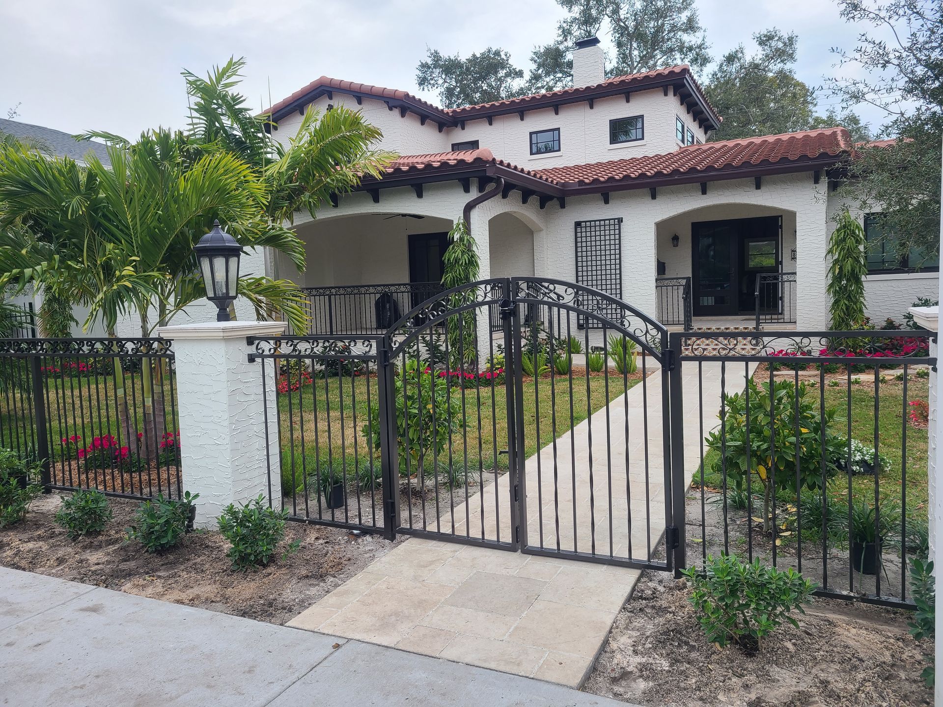 A van is parked behind a black gate in front of a house.