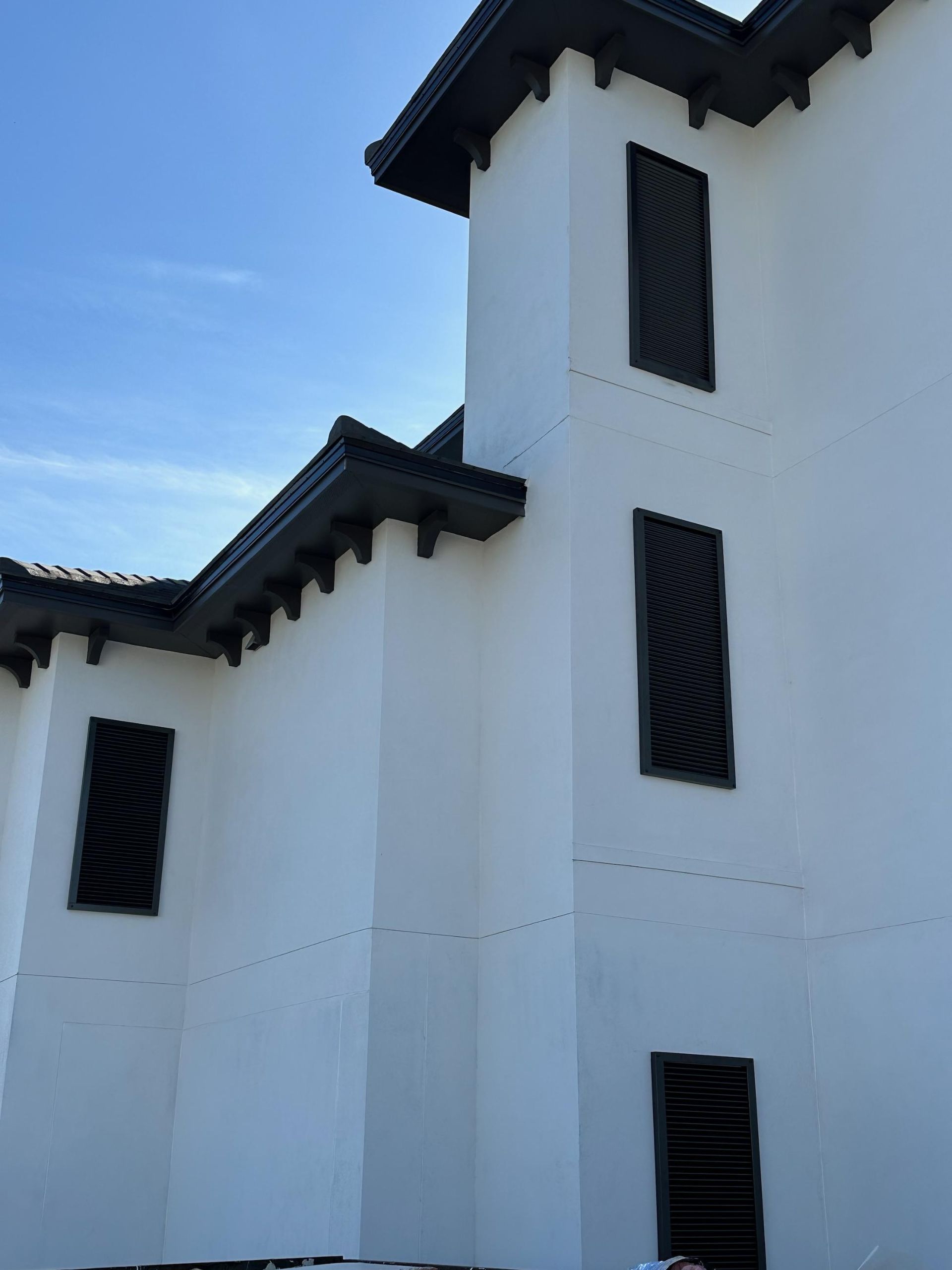 A white building with black shutters on the windows