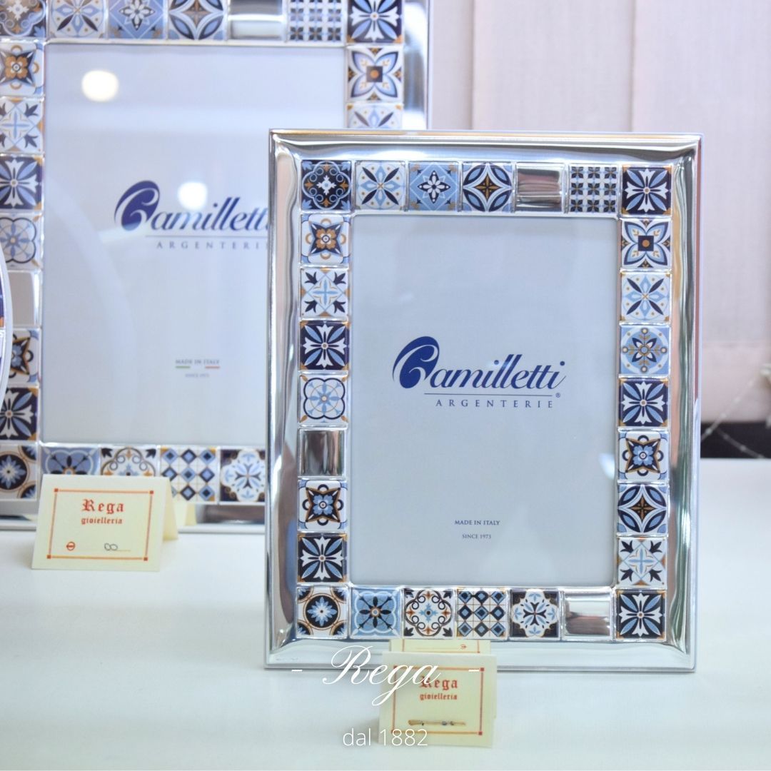 Una cornice con un disegno di piastrelle blu e bianche è appoggiata su un tavolo