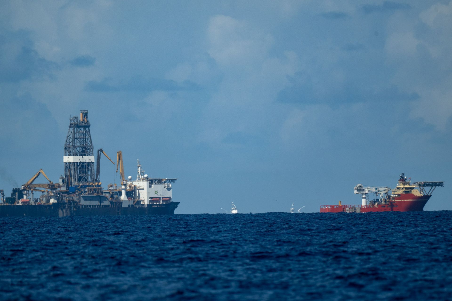 A couple of boats are floating on top of a large body of water.