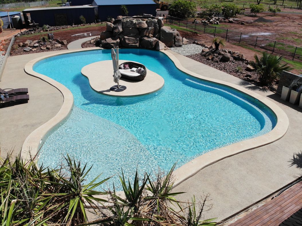 A Large Swimming Pool With A Small Island In The Middle — Pool Concepts in Howard Springs, NT