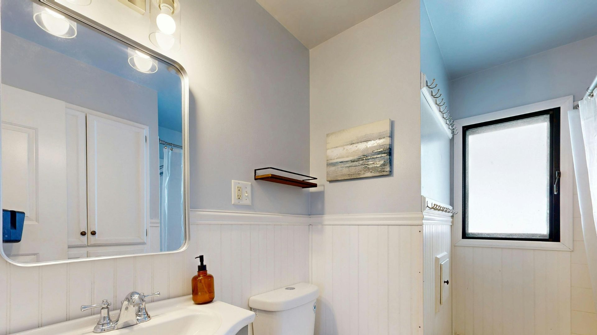 A modern, light-filled bathroom with a white freestanding tub, glass walk-in shower, and a vanity with dual faucets.