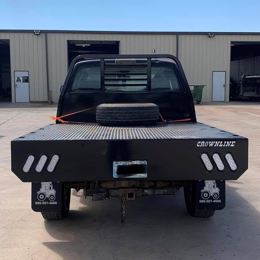 blue dodge truck with black flatbed and spare tire laying on the bed