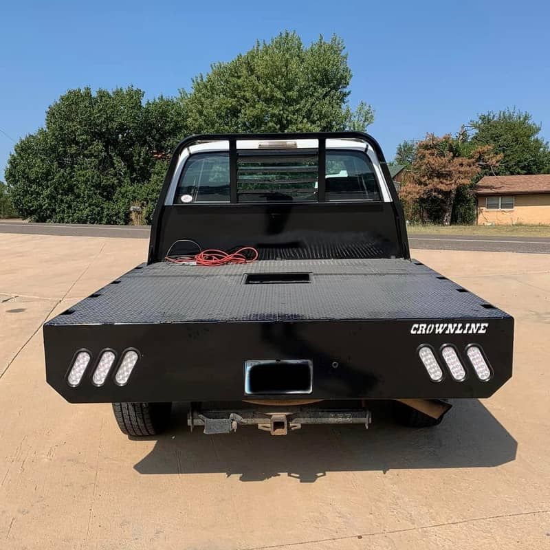 a crownline flatbed truck is parked on the side of the road