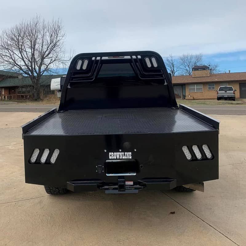 silver ford crew cab with black skirted flatbed rear view