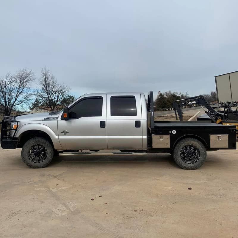 silver ford crew cab with black skirted flatbed wide view from side
