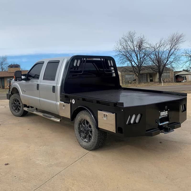 silver ford crew cab with black skirted flatbed rear angle