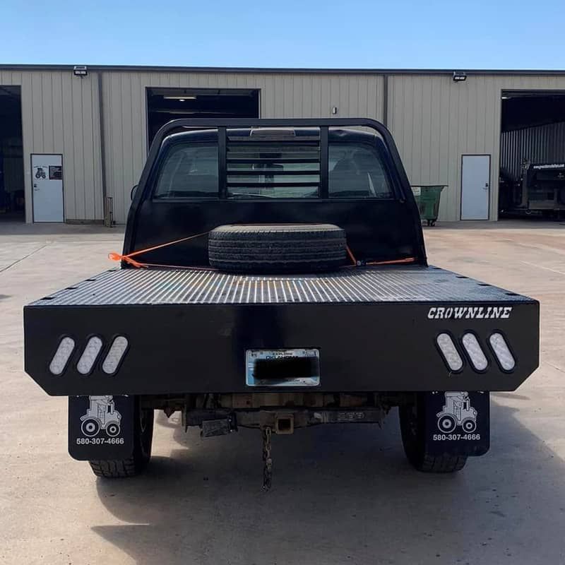 a crownline flatbed truck is parked in front of a building