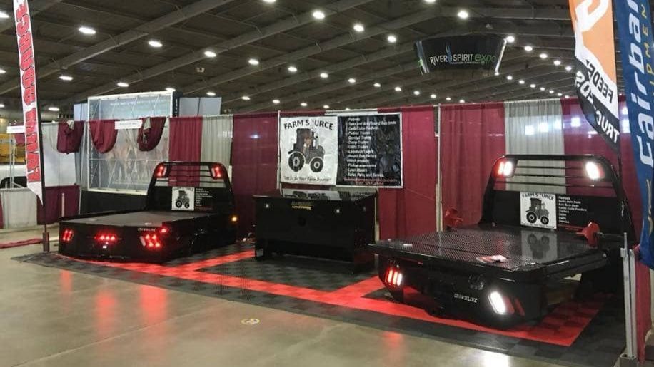truck beds displayed at trade show with curtain divider background