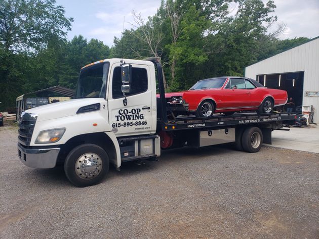 A truck is being towed by a tow truck