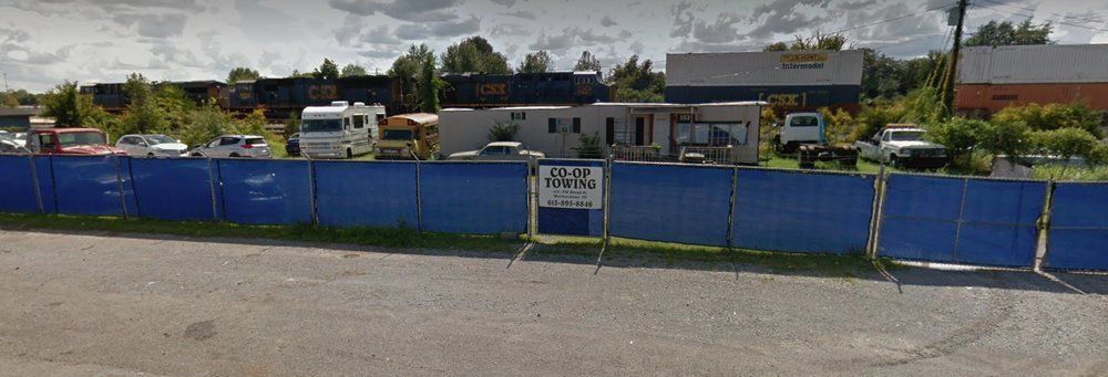 A blue fence surrounds a parking lot with a sign that says rv park here.