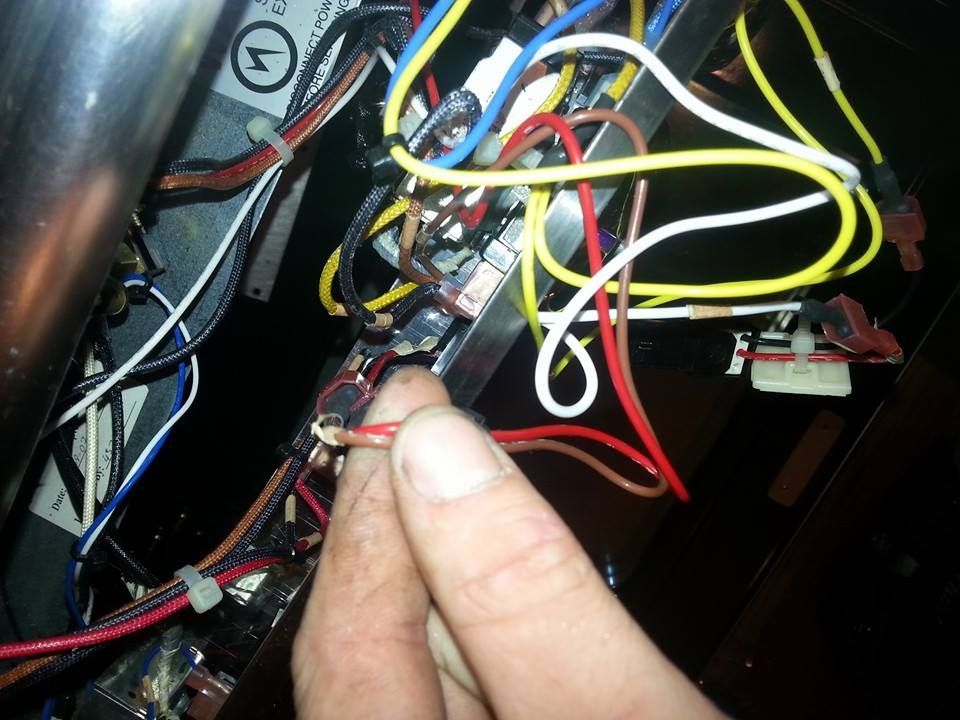 A close up of a person holding a red wire