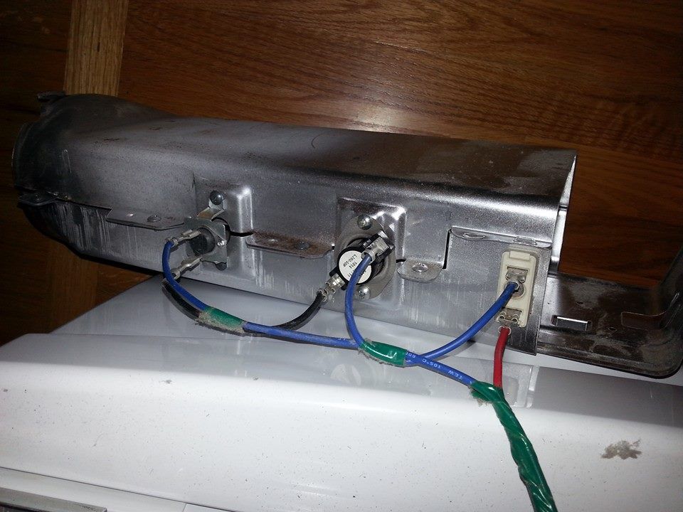 A piece of metal with wires attached to it is sitting on a white surface.