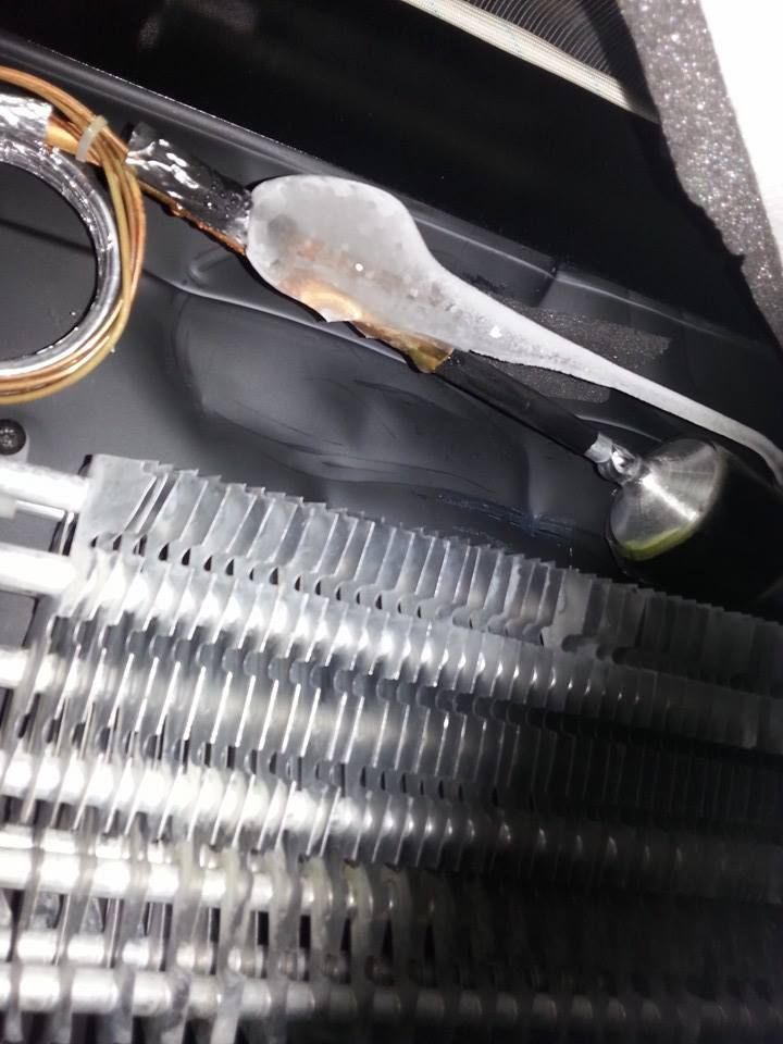 A close up of a refrigerator with a hose attached to it