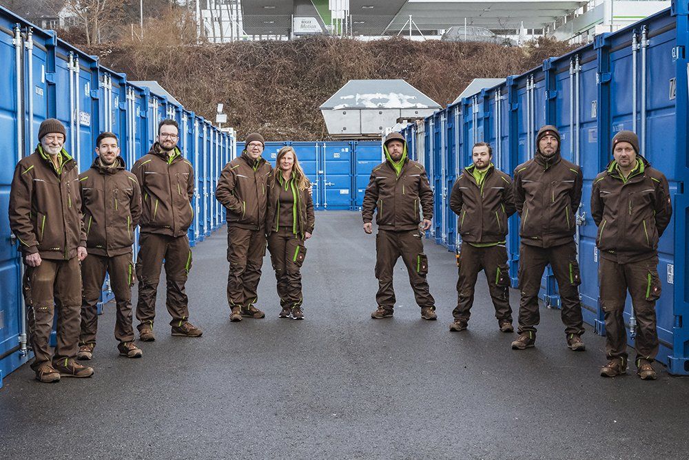 Gruppenfoto des Teams von FAIR TRANSPORT (9 Personen) in Winterkleidung, aufgestellt in einem Halbkreis.