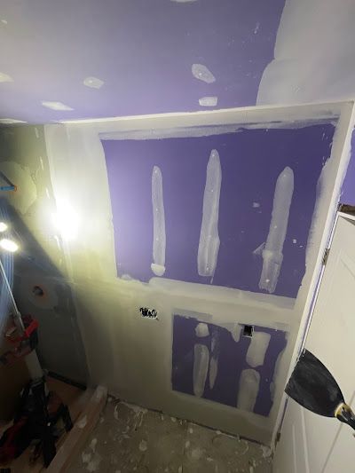 A room with a purple wall and a white door