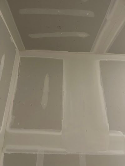A room with a ceiling made of drywall and a few holes in it.