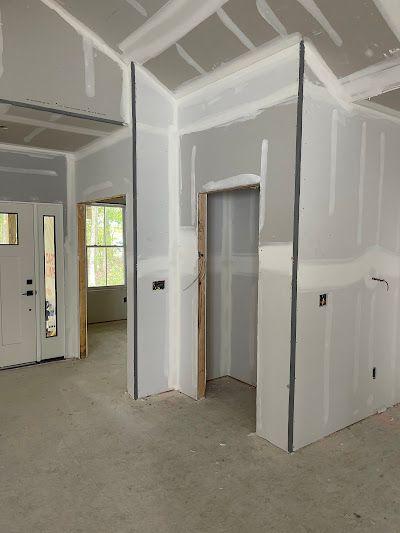 A room with drywall on the walls and a door.