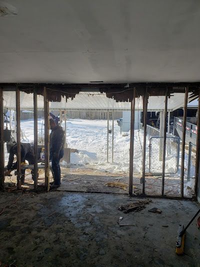 A man is standing in a room with a lot of windows.