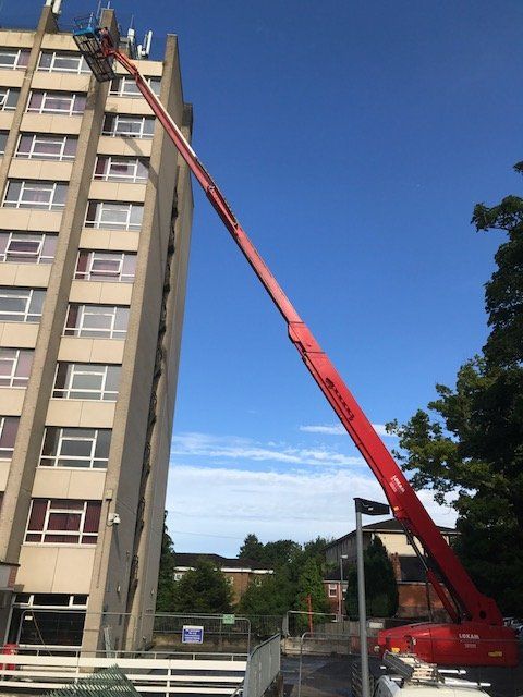 A crane at full extension up a high rise building at Cardiff University