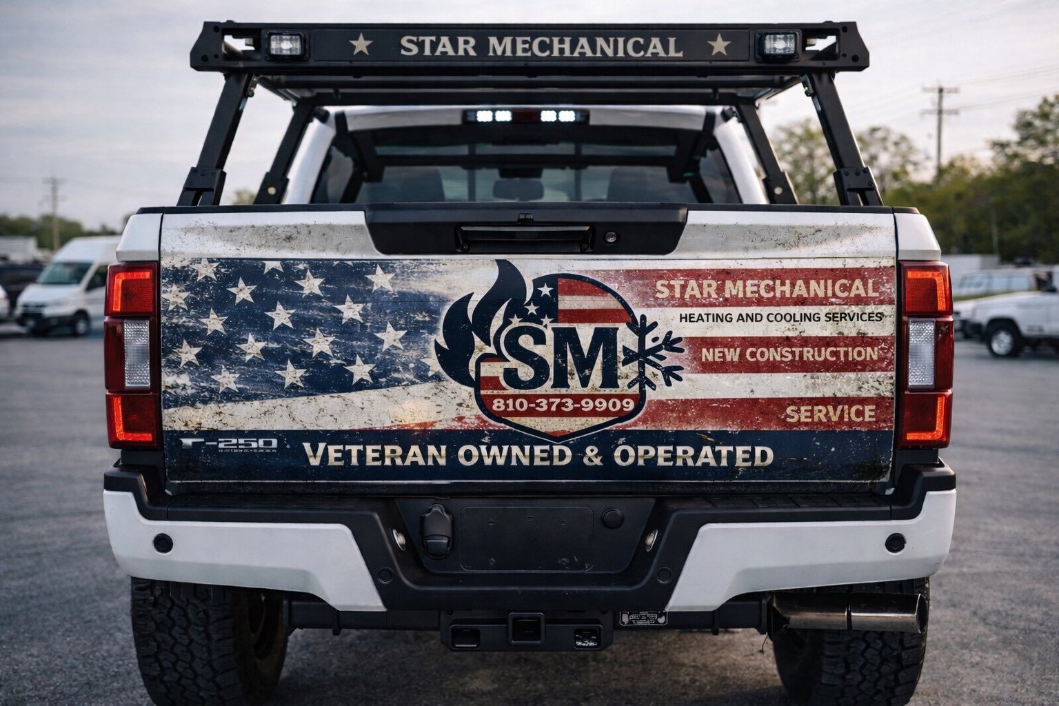 Rear view of a white Ford F-250 pickup truck with a tailgate wrap featuring an American flag and Star Mechanical branding.