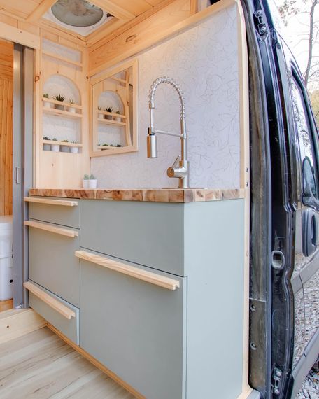 a kitchen in a van with a sink and drawers