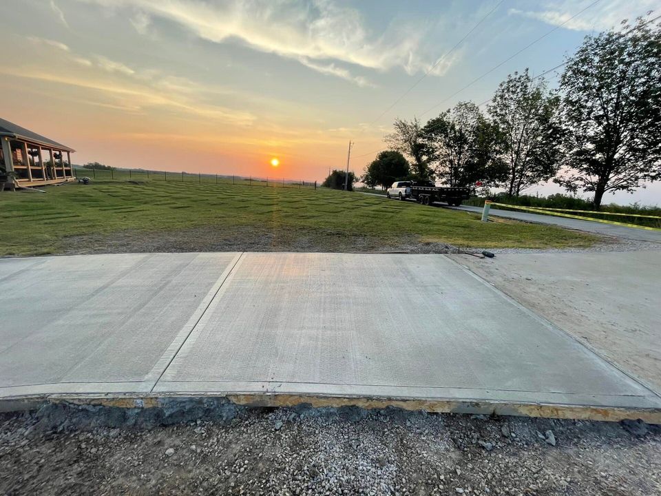 A concrete driveway with a sunset in the background.