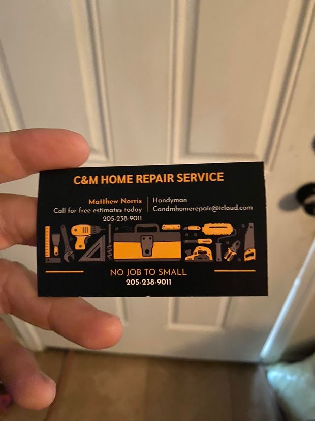 A hand holding a business card for C&M Home Repair Service with tools illustration.