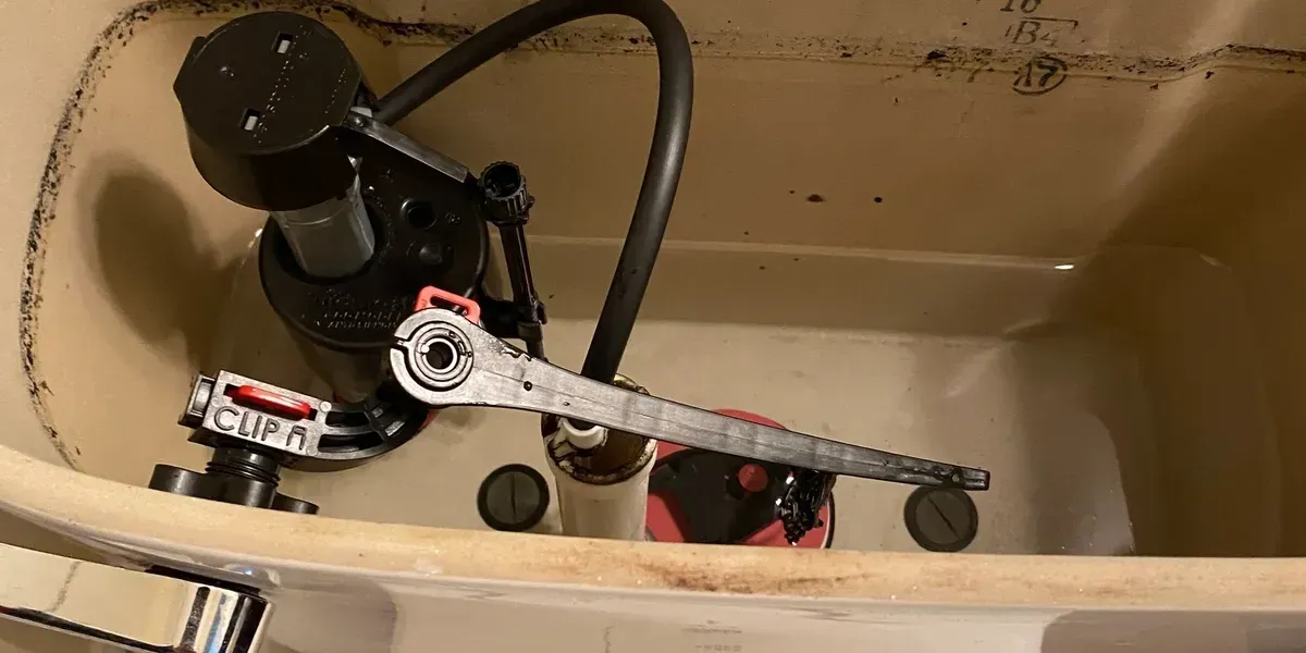 Toilet tank interior with black and red components.