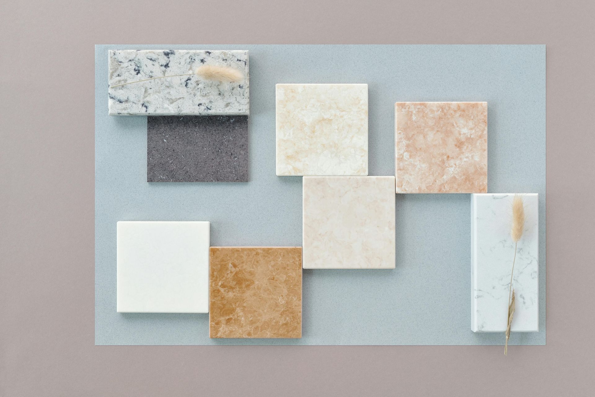 A neutral-toned design board featuring various square and rectangular stone samples.