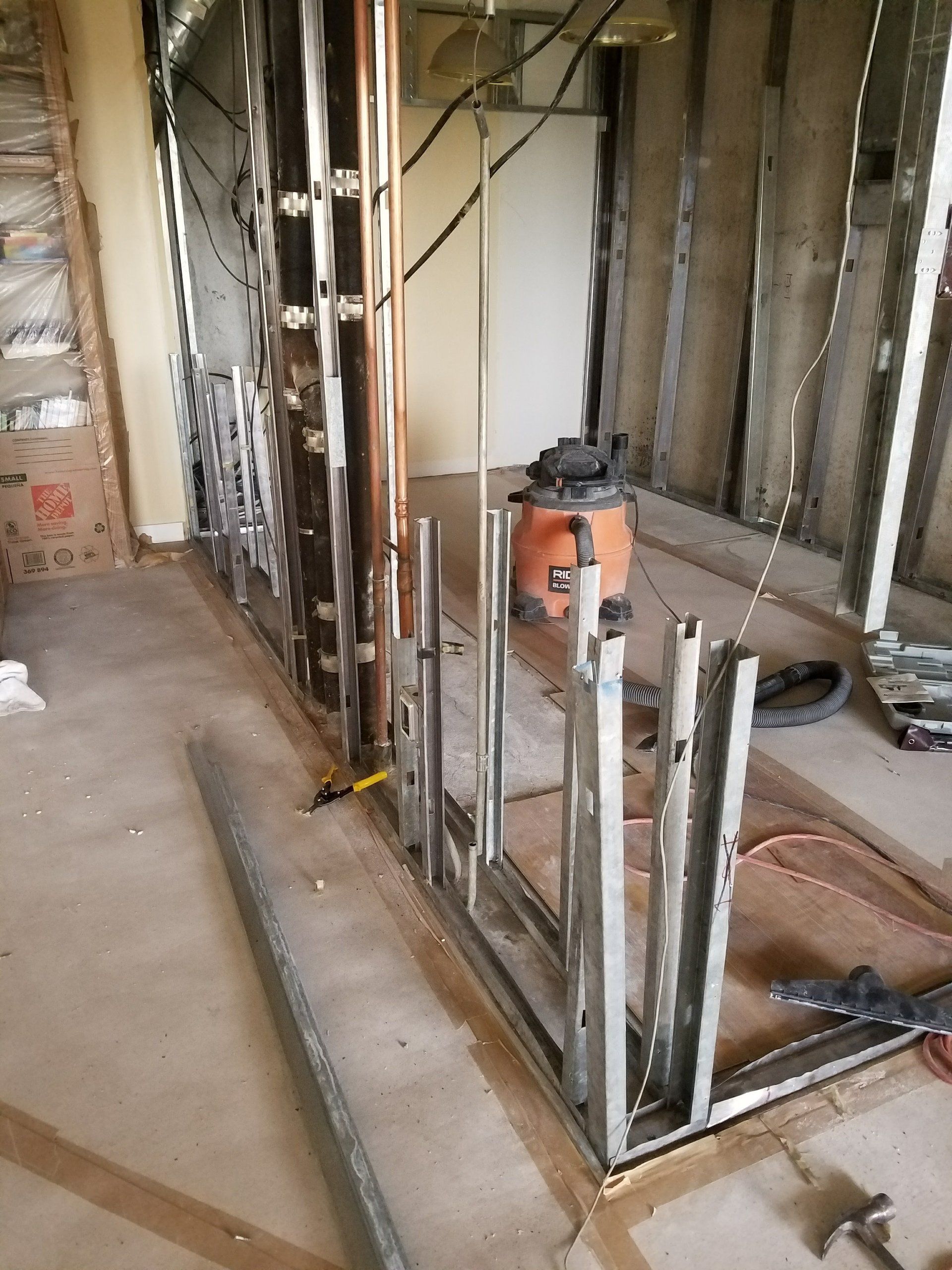 A room under construction with a vacuum cleaner in it.