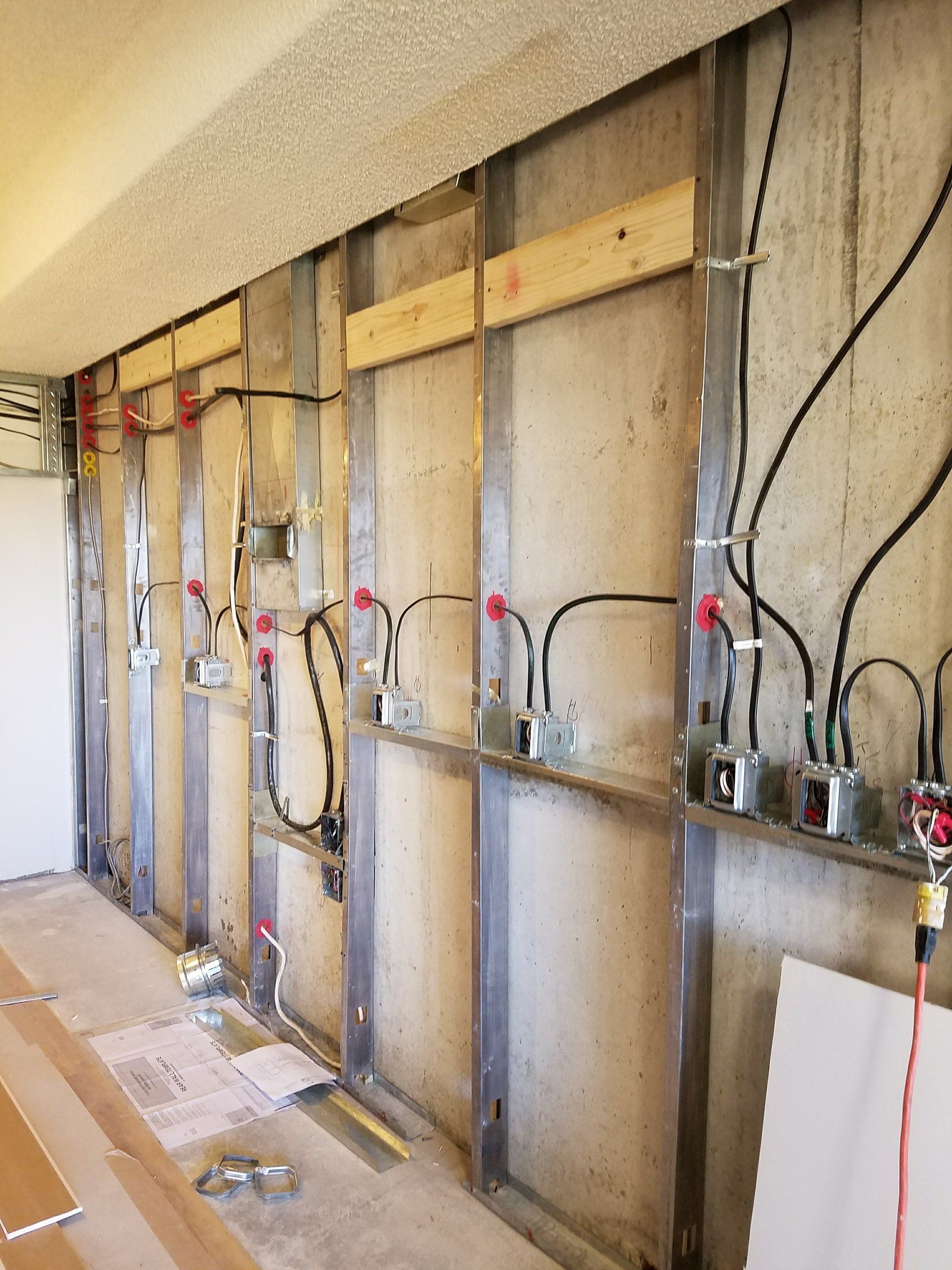 A wall with a lot of wires coming out of it.