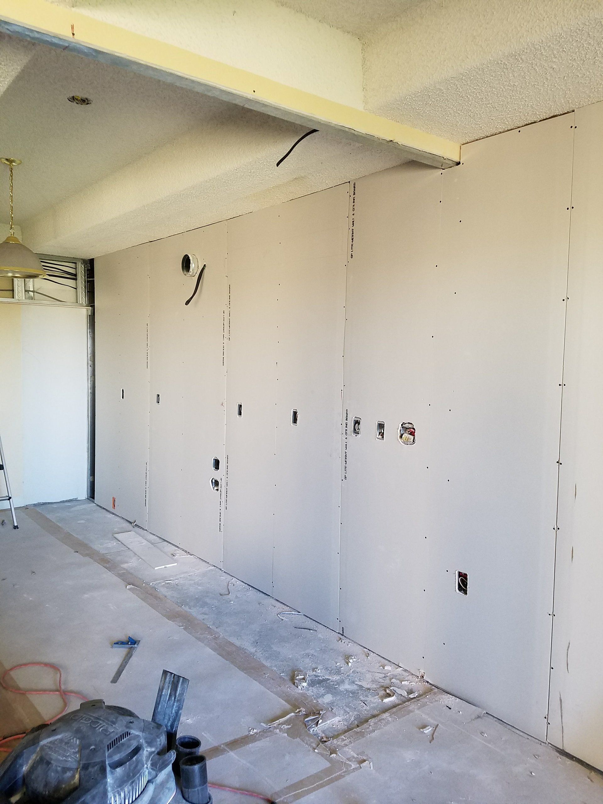 A room with a lot of walls and a hammer on the floor.