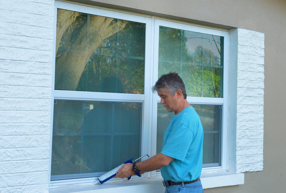 Applying Weatherproofing On House Window — Pensacola, FL — Protected Painting Services