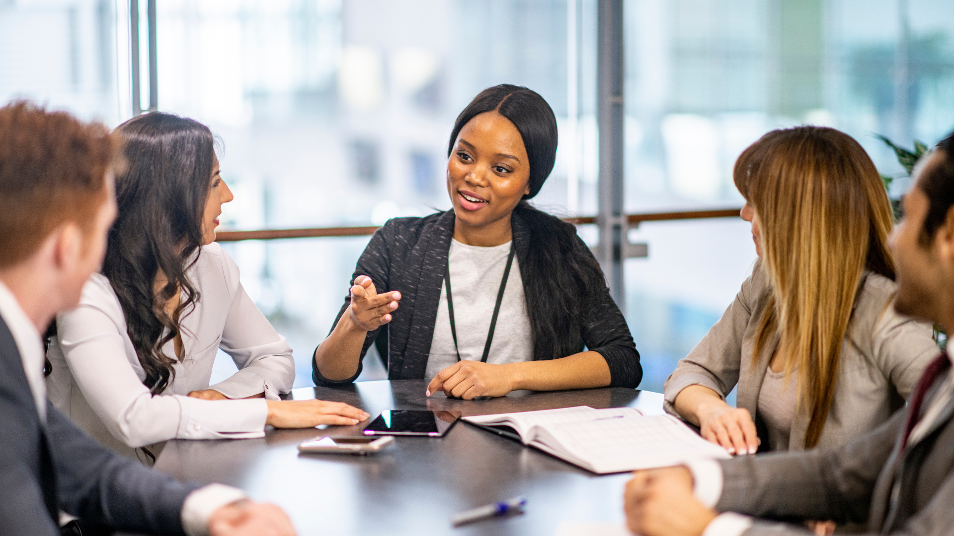 a group of people are sitting around a table having a meeting