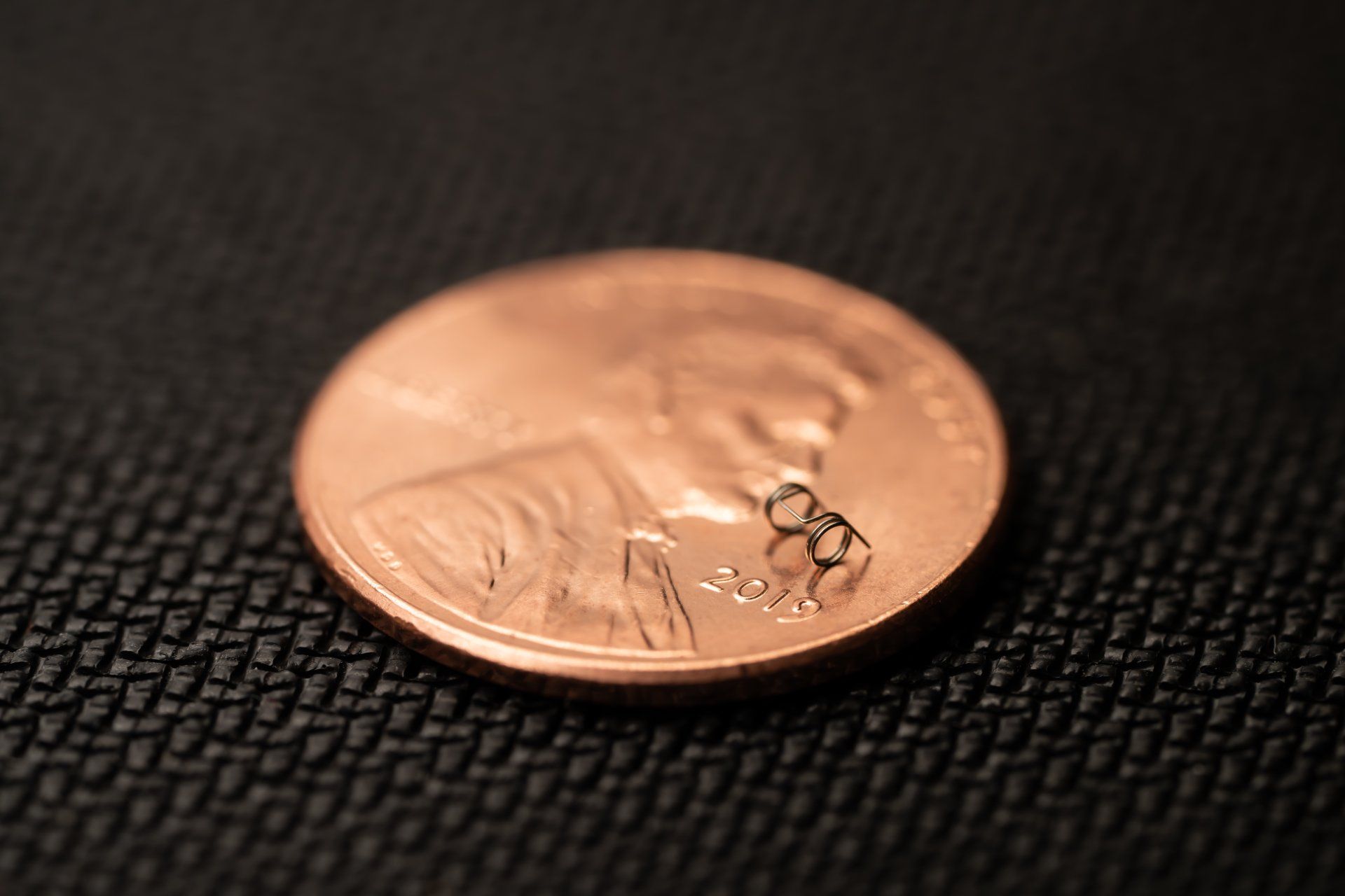 A close up of a penny on a black surface