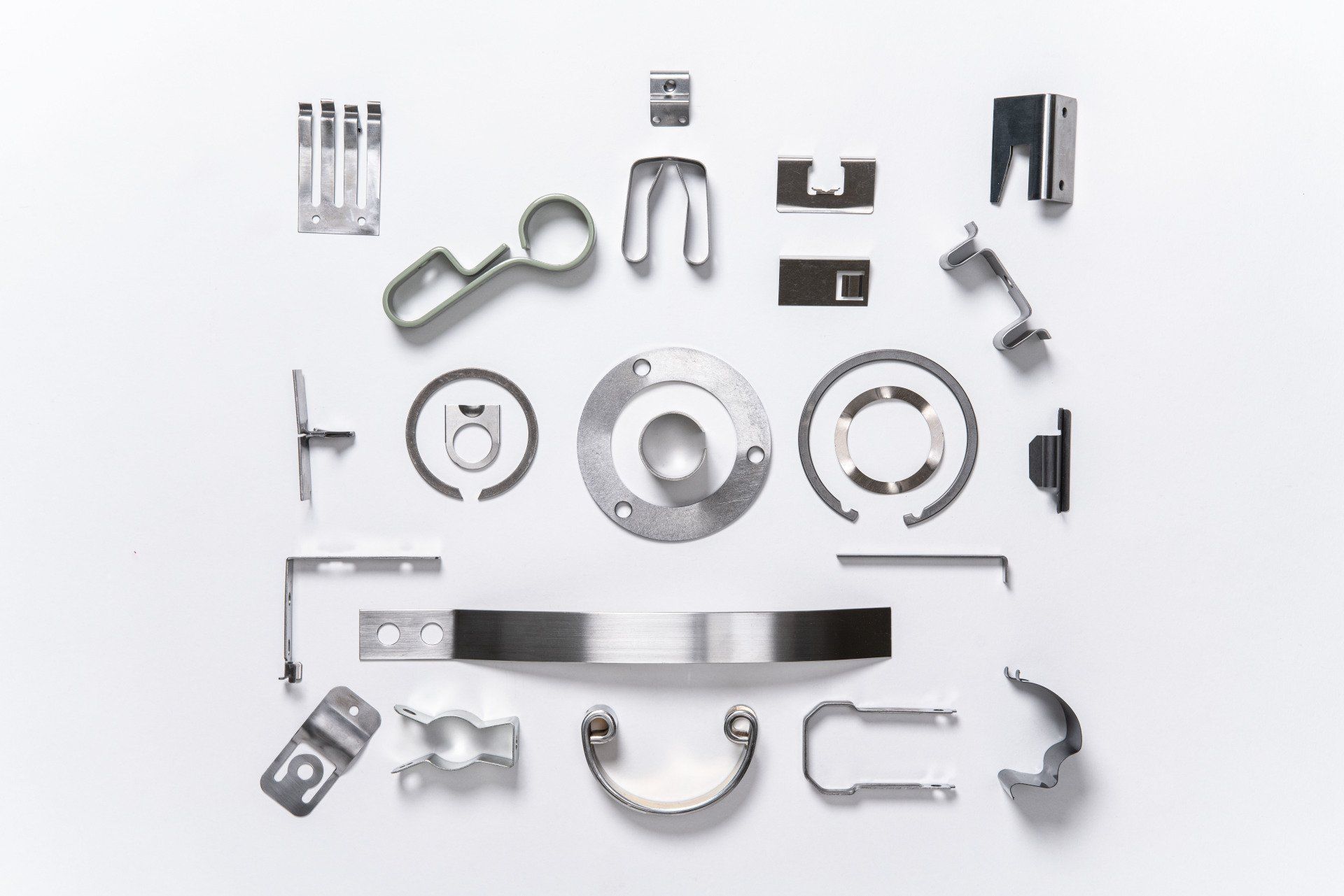 A bunch of metal parts are laying on a white surface.