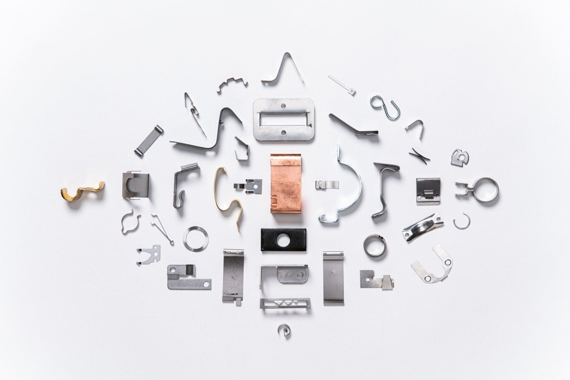 A bunch of metal parts are laying on a white surface.