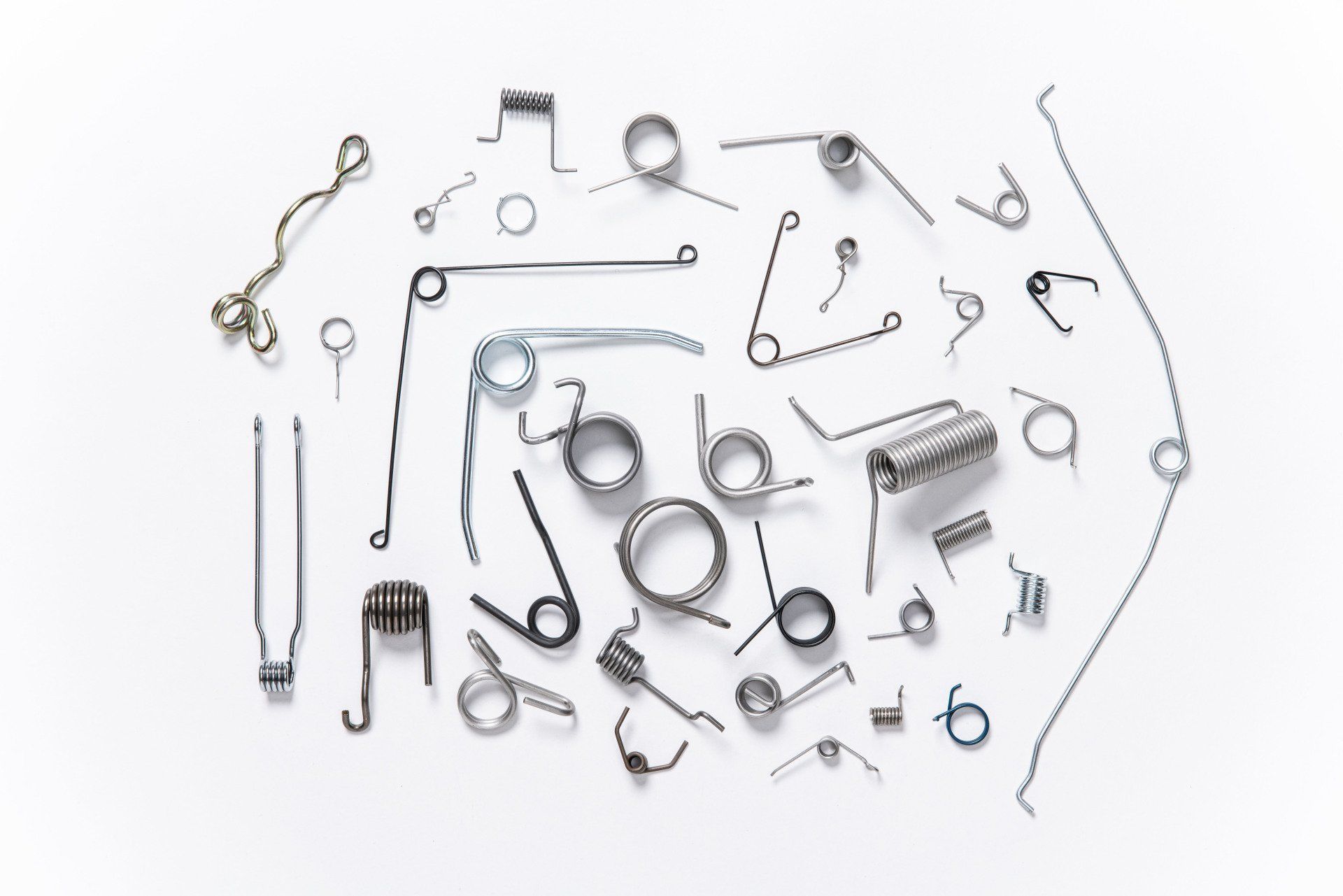 There are many different types of springs on a white surface.