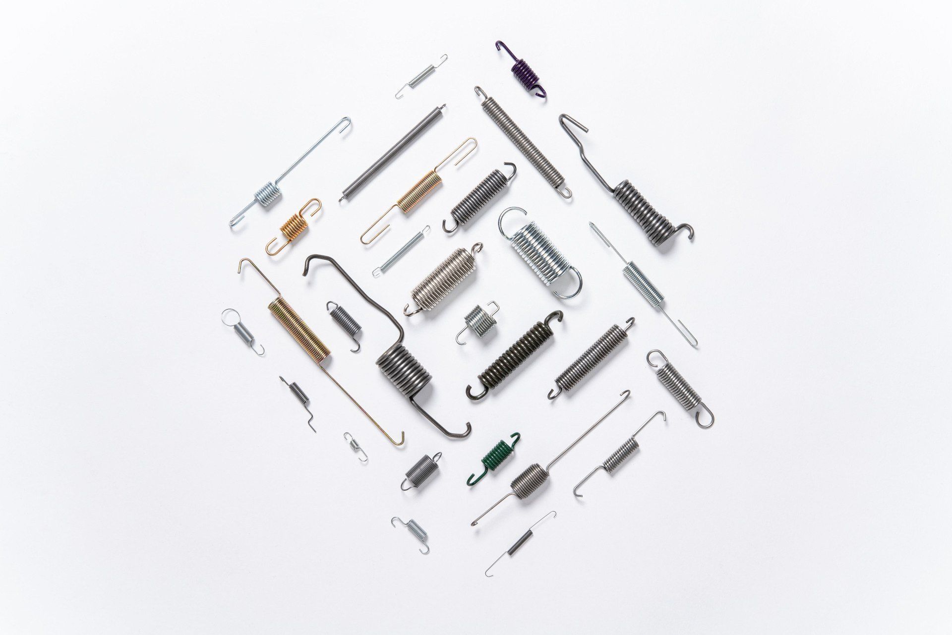 There are many different types of springs on a white surface.