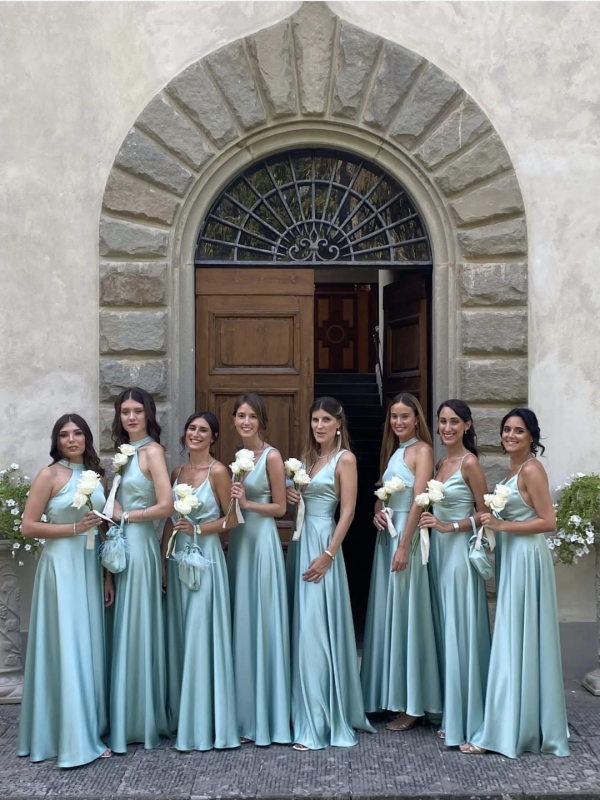 Un gruppo di damigelle posa per una foto davanti a un edificio