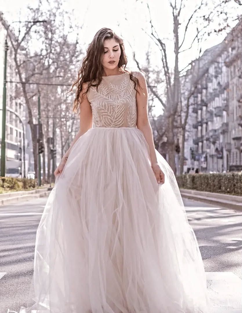 Una donna con un abito da sposa bianco è in piedi su una strada.