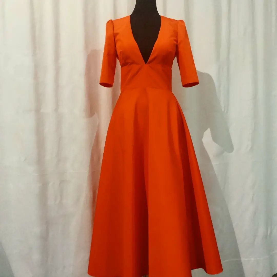 Un manichino indossa un vestito arancione con una profonda scollatura