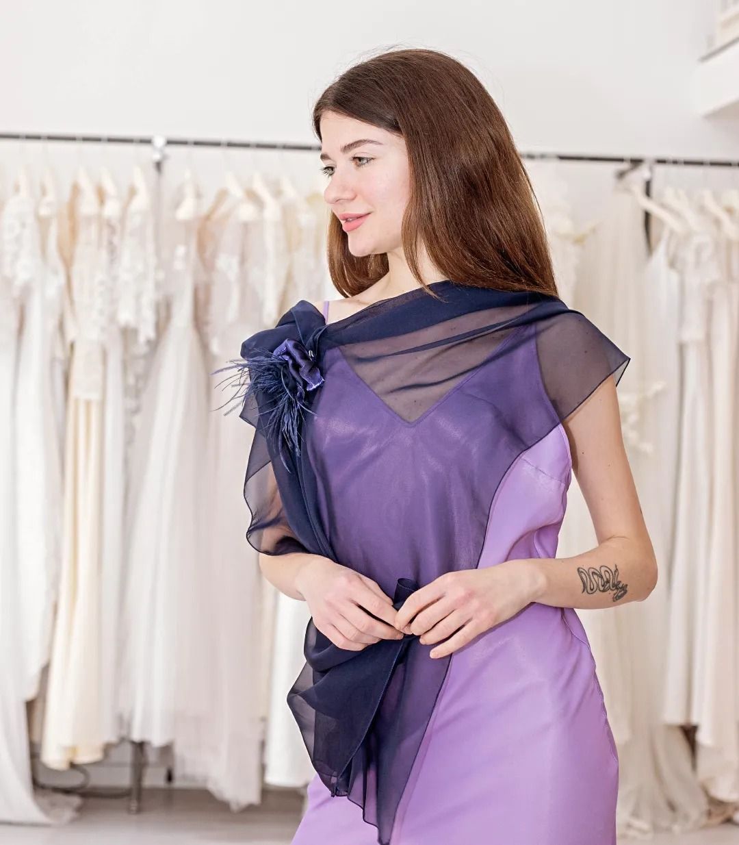 Una donna indossa un vestito viola e una sciarpa blu.