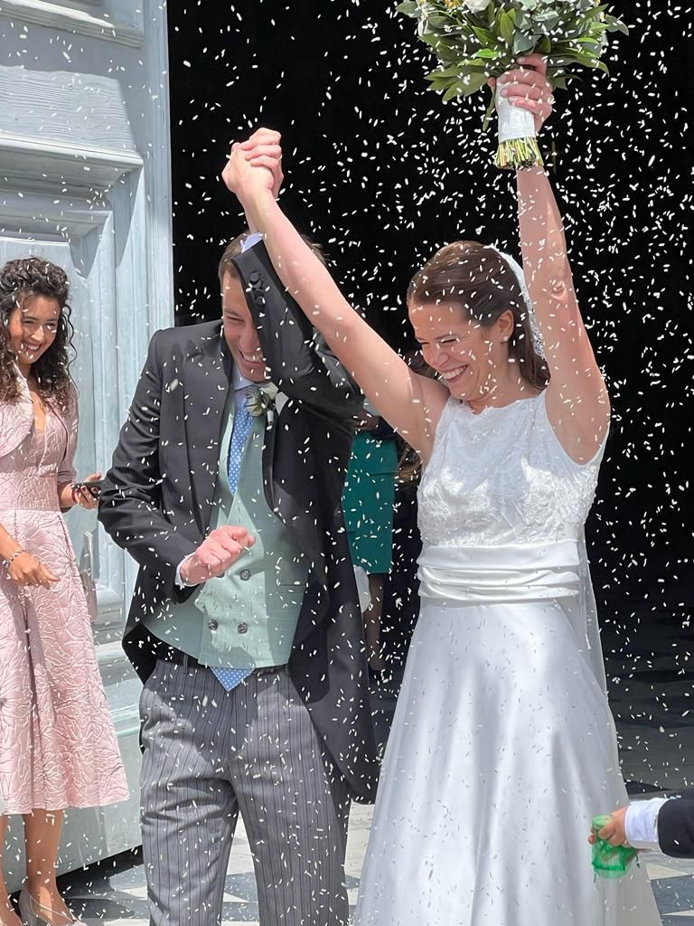 Una sposa e uno sposo vengono ricoperti di riso durante le loro nozze.