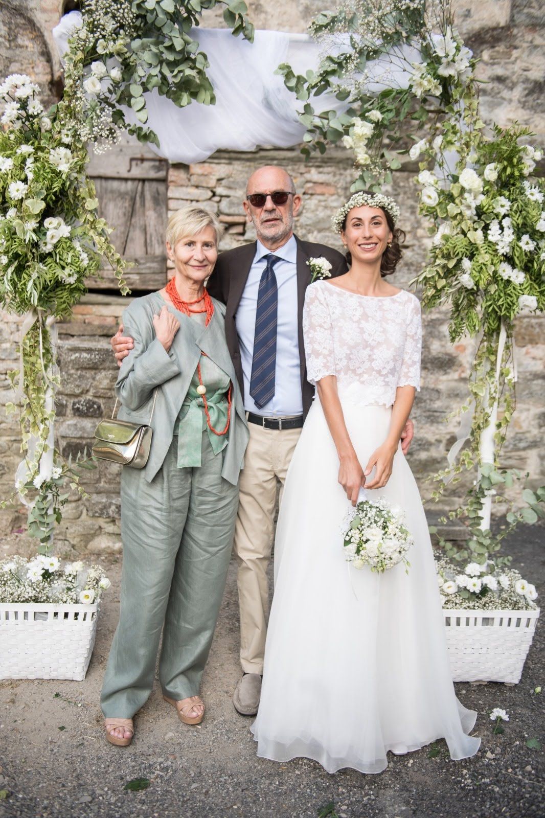 Una coppia di sposi posano per una foto con i loro genitori.