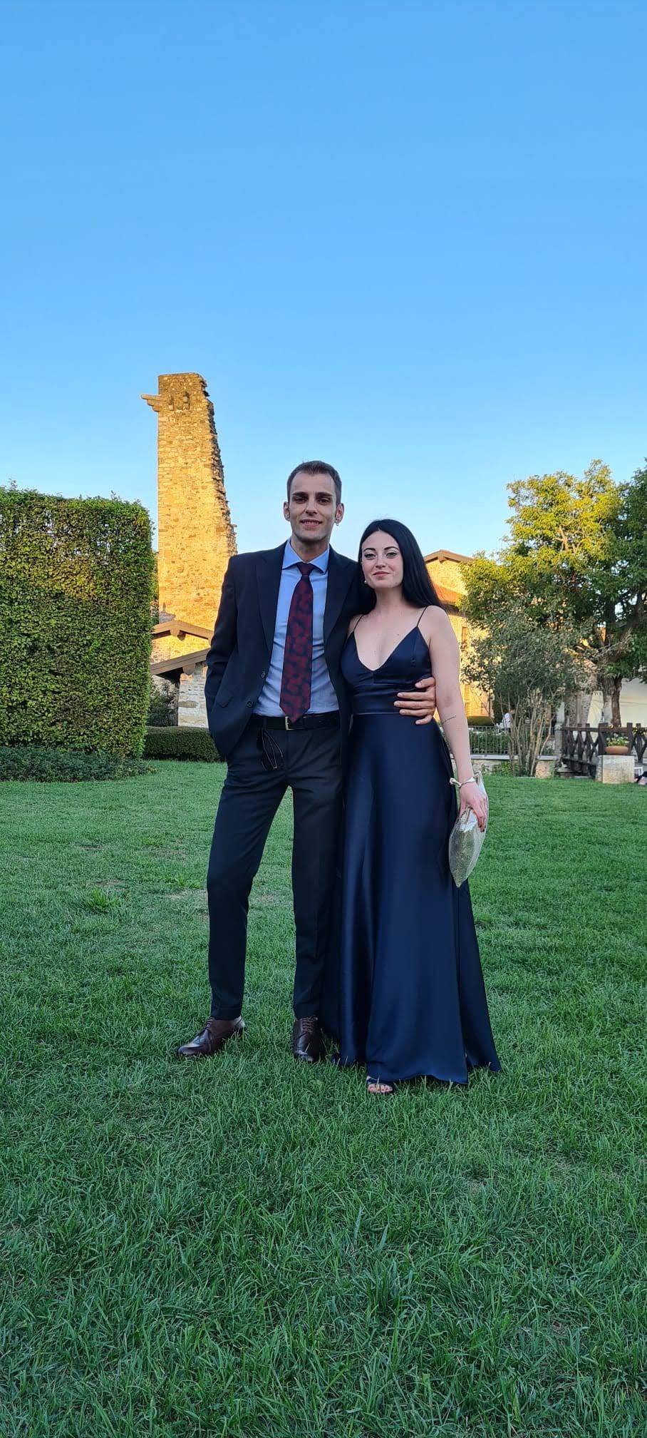 Un uomo e una donna posano per una foto in un campo erboso.