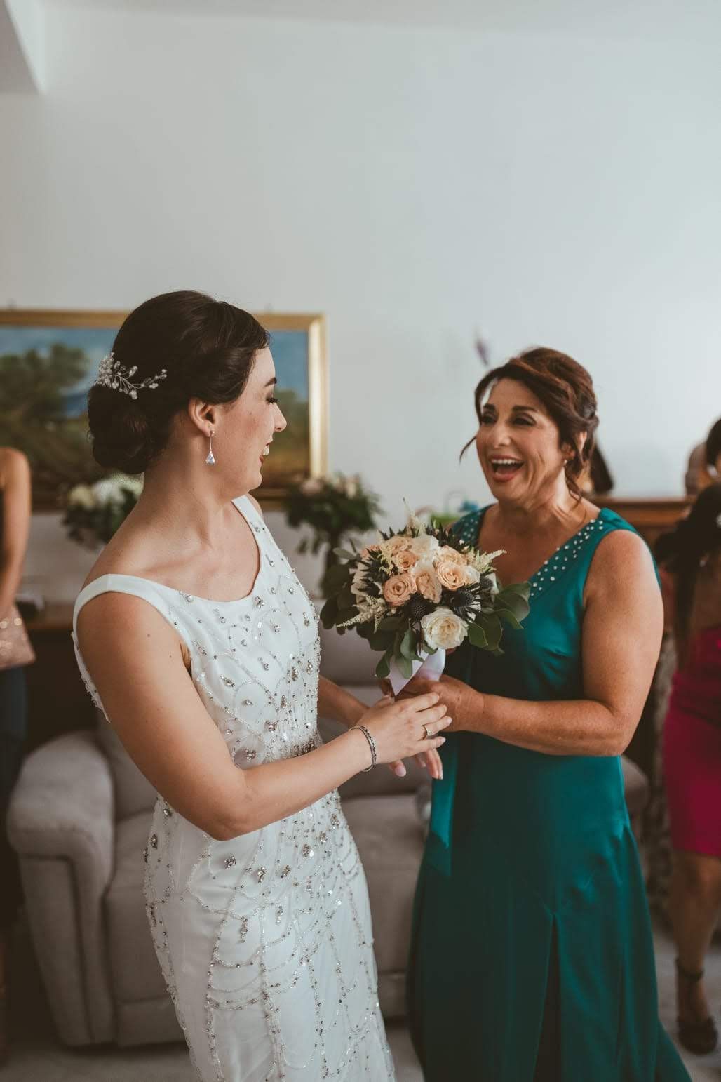 La sposa tiene in mano un mazzo di fiori e parla con la madre.