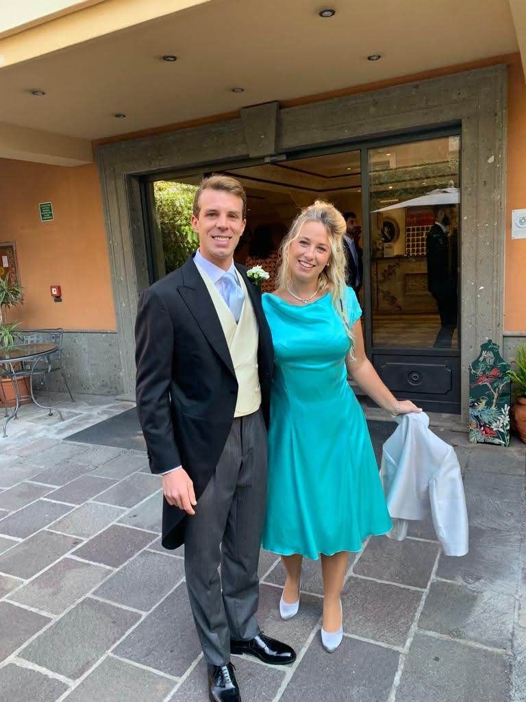 Un uomo e una donna posano per una foto davanti a un edificio.